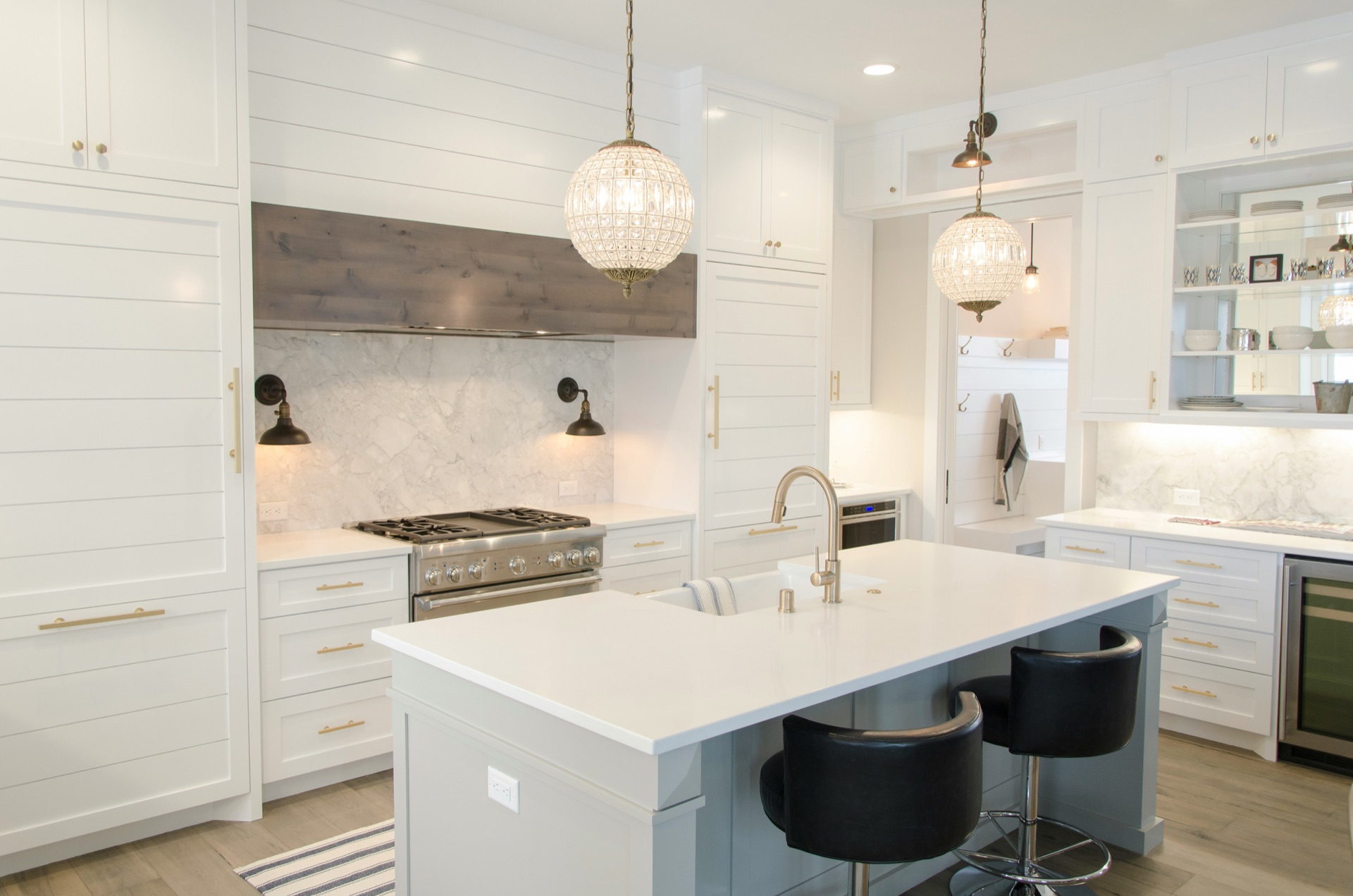 Modern white kitchen with crystal pendant lights and undercabinet LED lighting