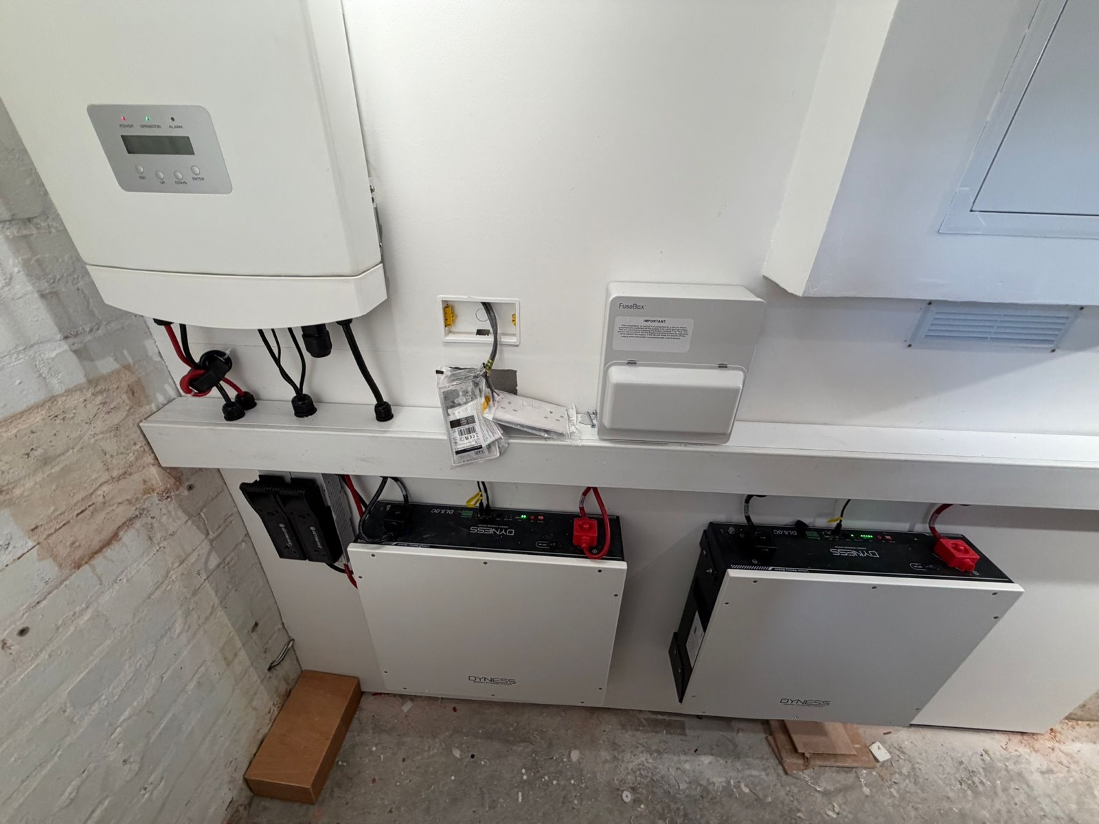 An inverter and two wall-mounted battery units installed in a utility space in Aylesbury
