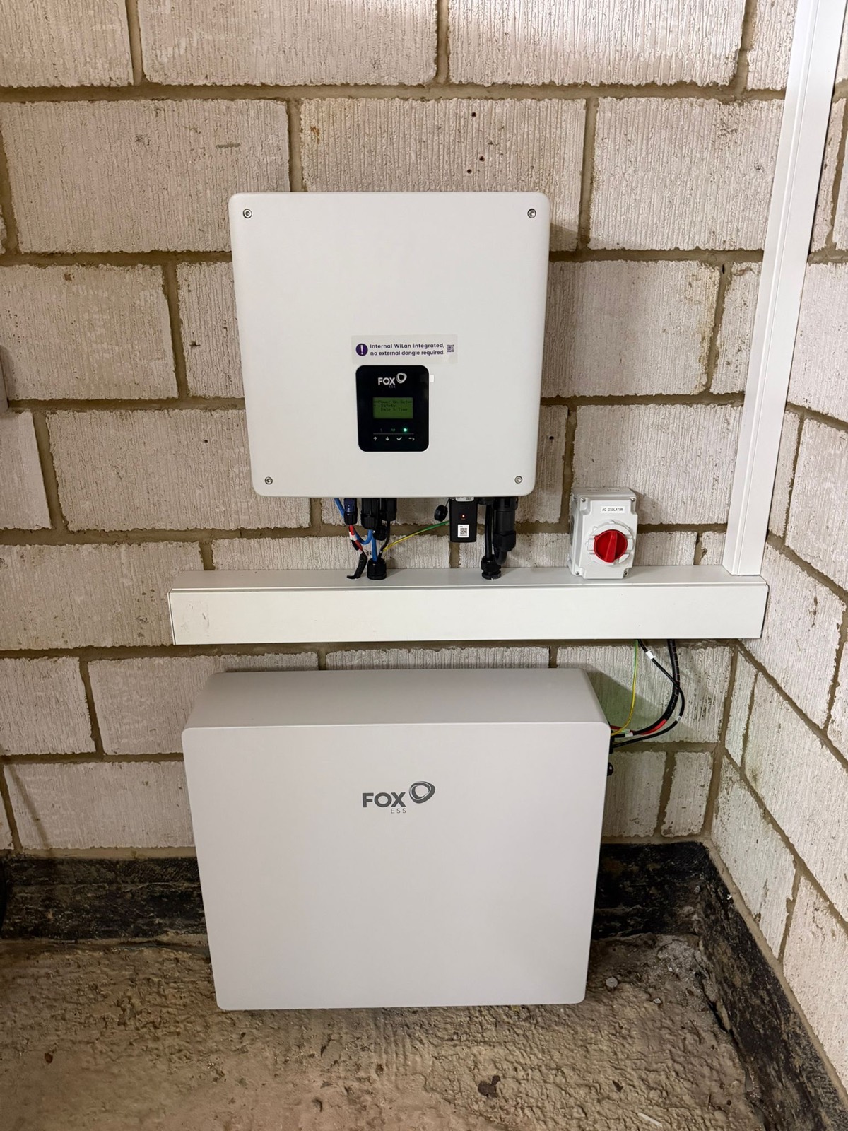 A Fox ESS AC-coupled inverter and floor-standing battery fitted to a garage wall in Greens Norton