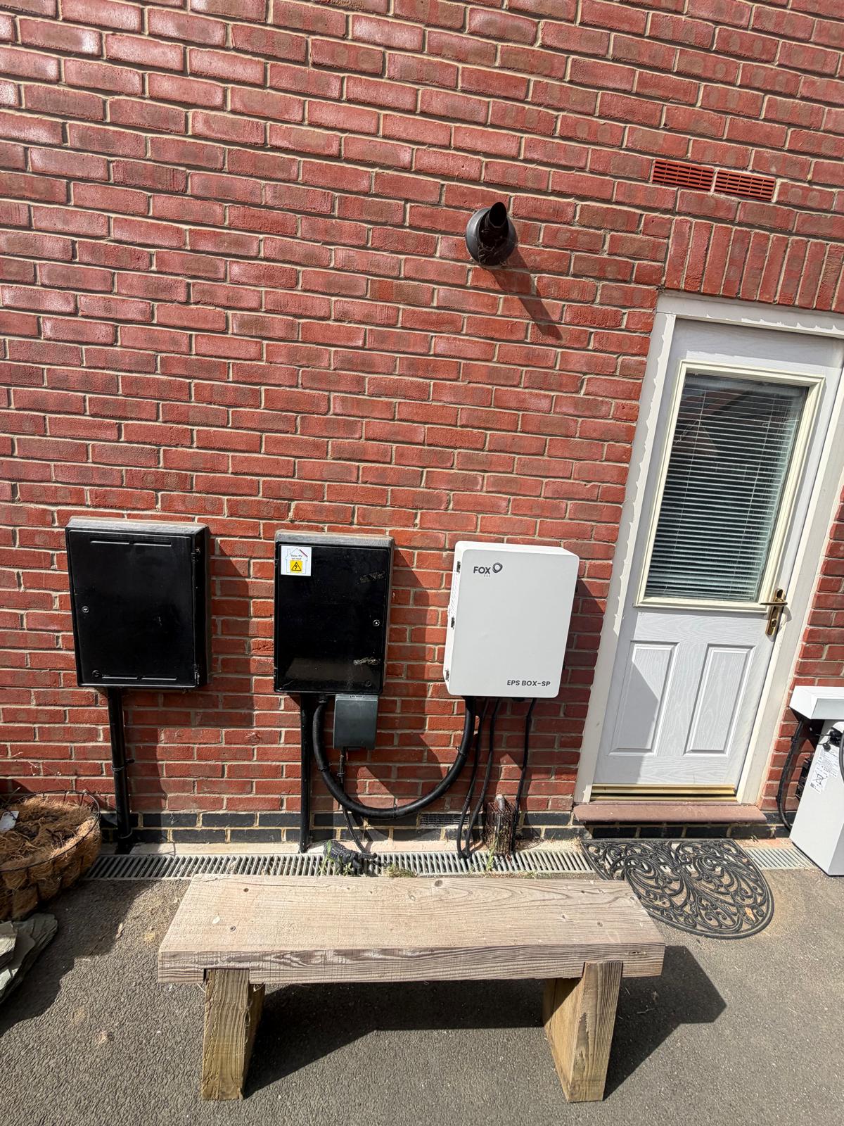 A Fox ESS EPS backup box and isolators mounted on an exterior brick wall