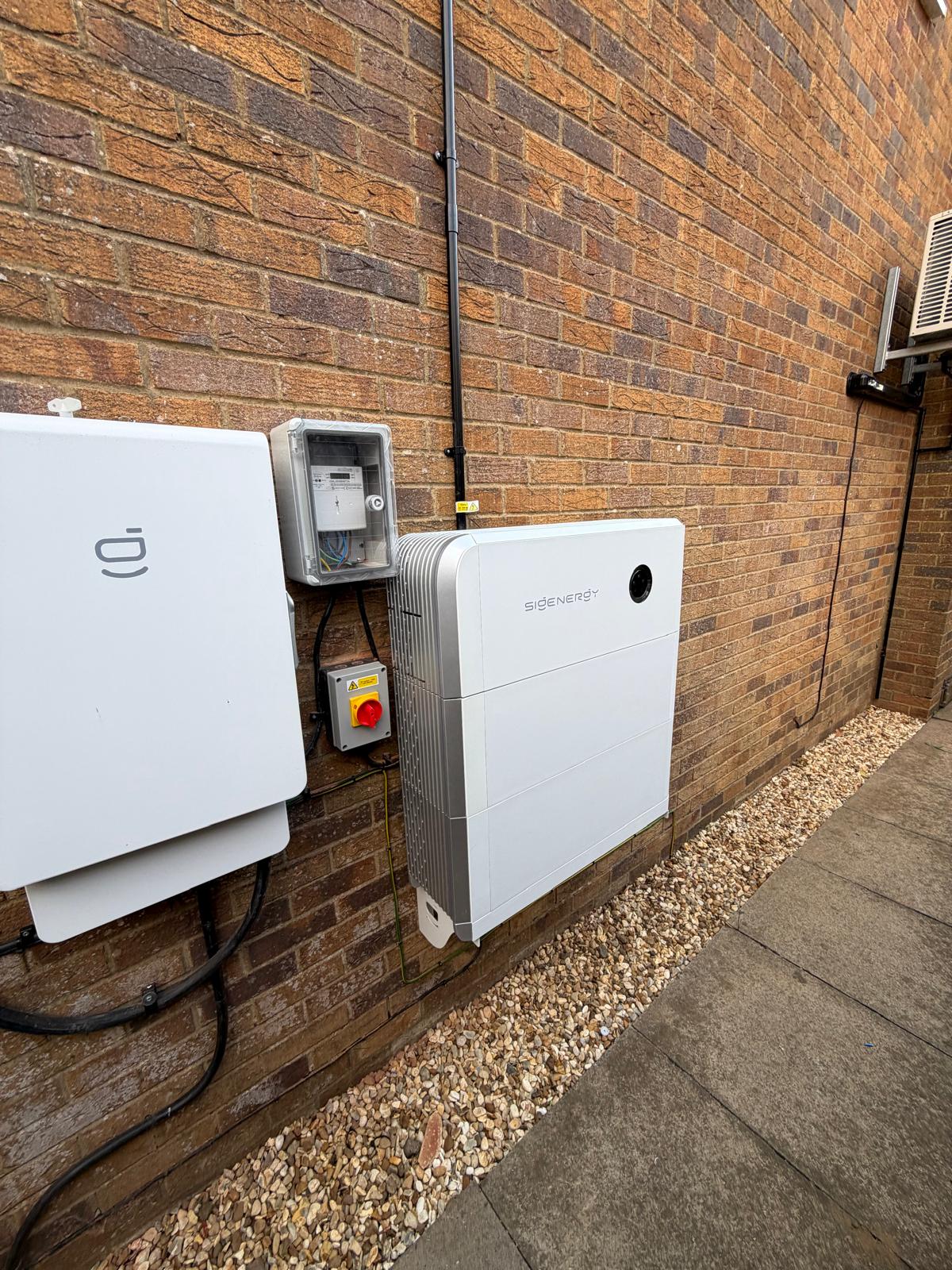 A Sigenergy SigenStor inverter and battery unit on an exterior wall in Maidford