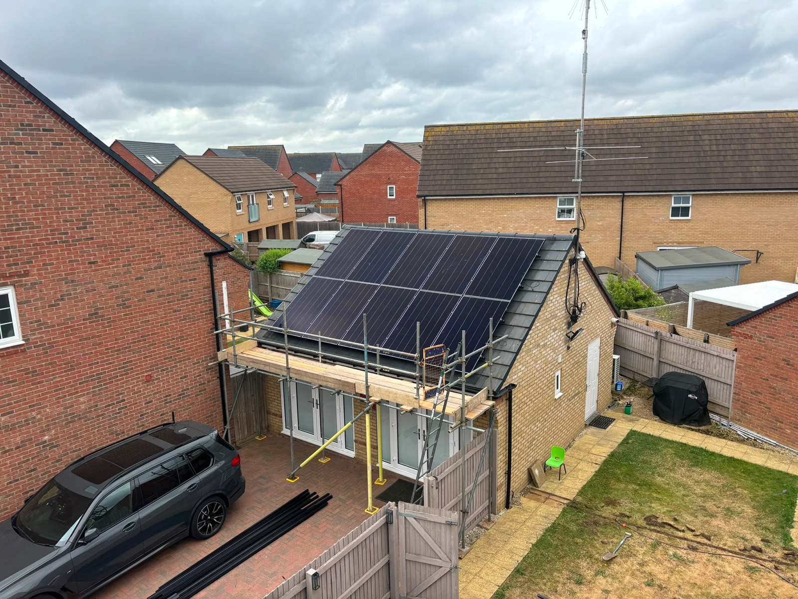 A large black solar array covering a garage roof in Milton Keynes, seen from above