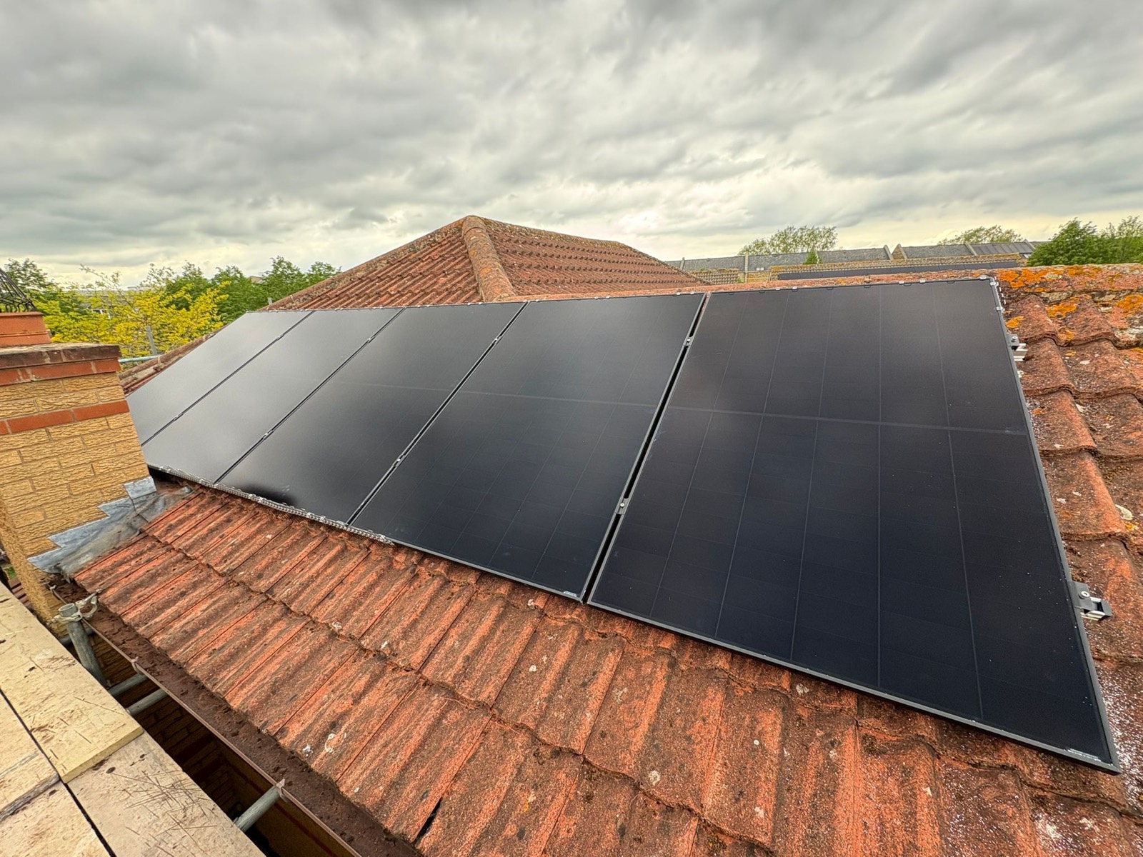 All-black solar panels across two faces of a tiled roof in Milton Keynes