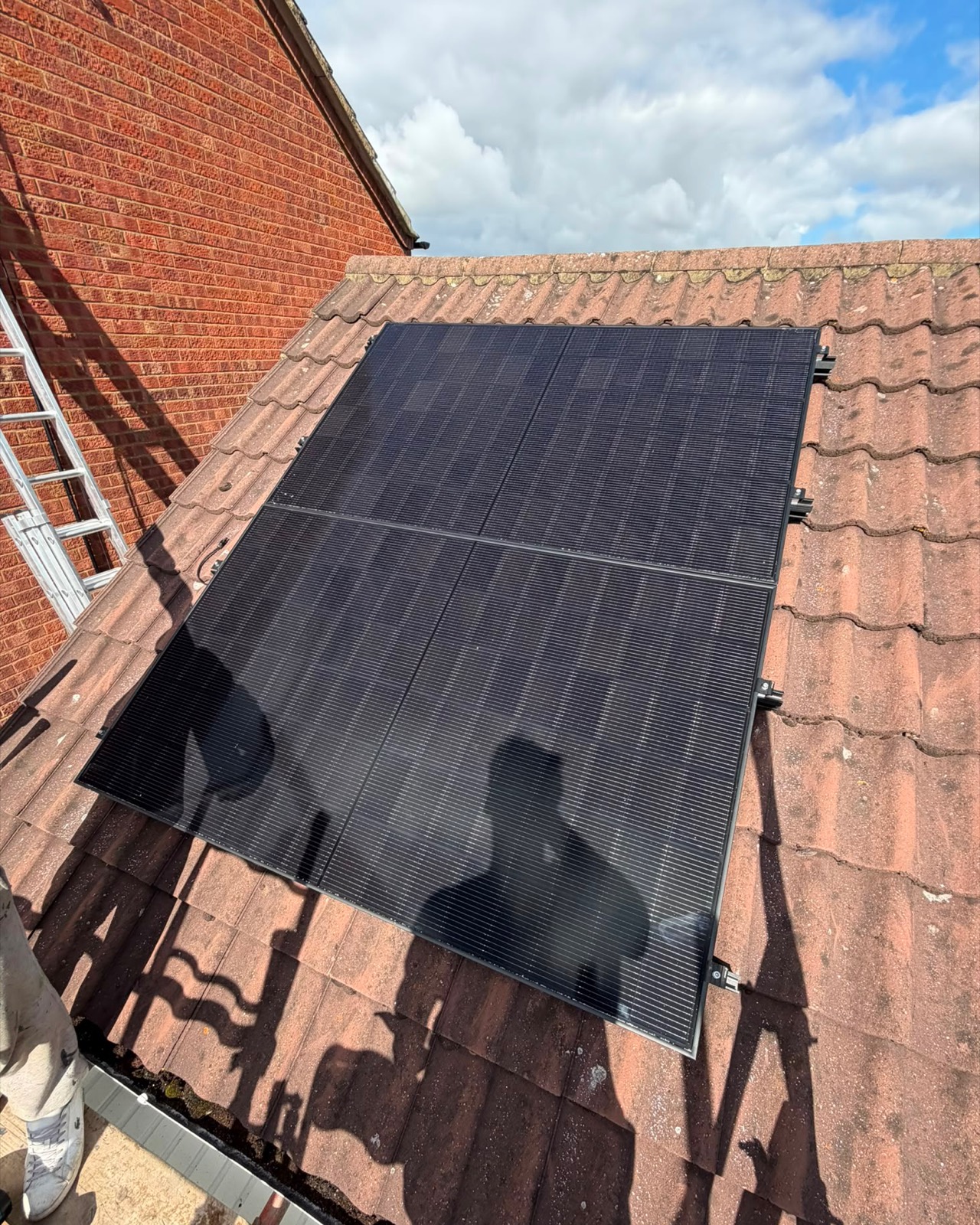 Two solar panels fitted to a garage roof alongside the main house array