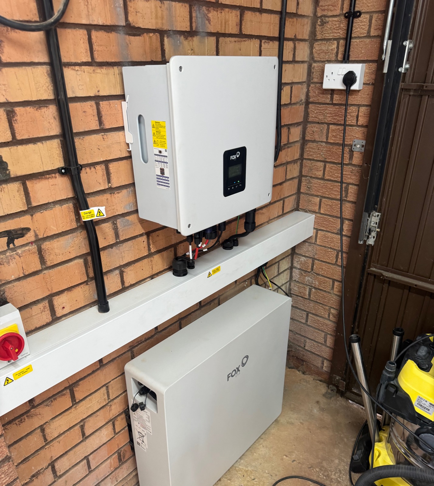 A Fox ESS hybrid inverter and battery installed in a garage
