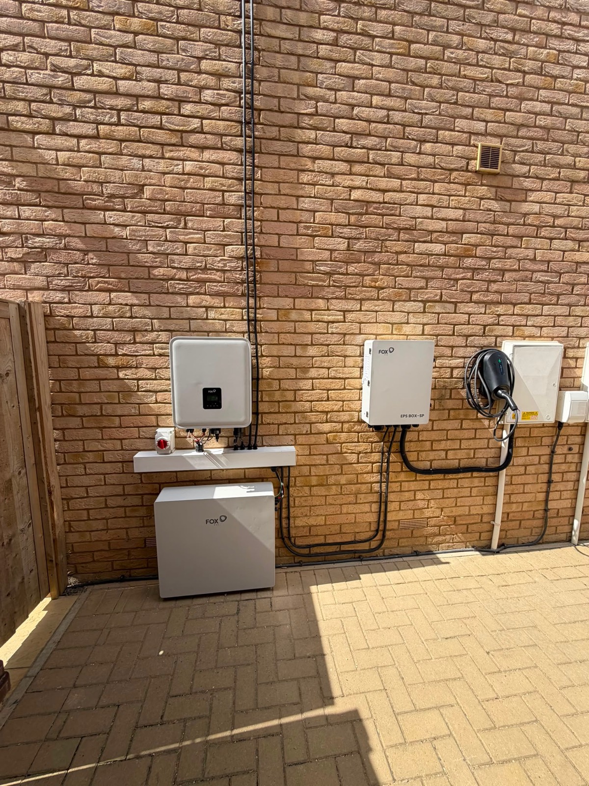 A Fox ESS inverter, outdoor battery and EPS backup box fitted to an outside wall