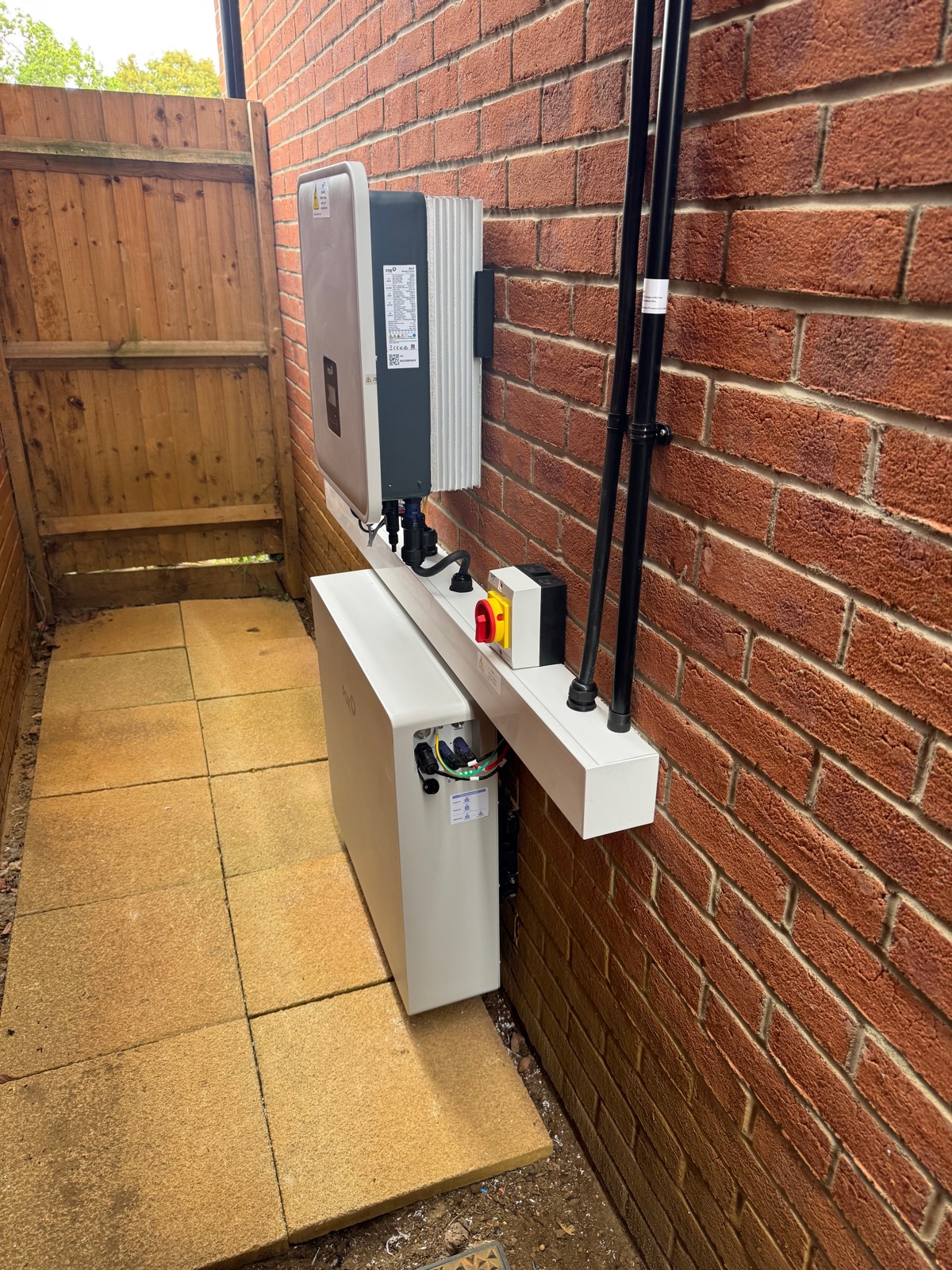 A Fox ESS hybrid inverter and battery installed on the side wall of a house in Welwyn Garden City