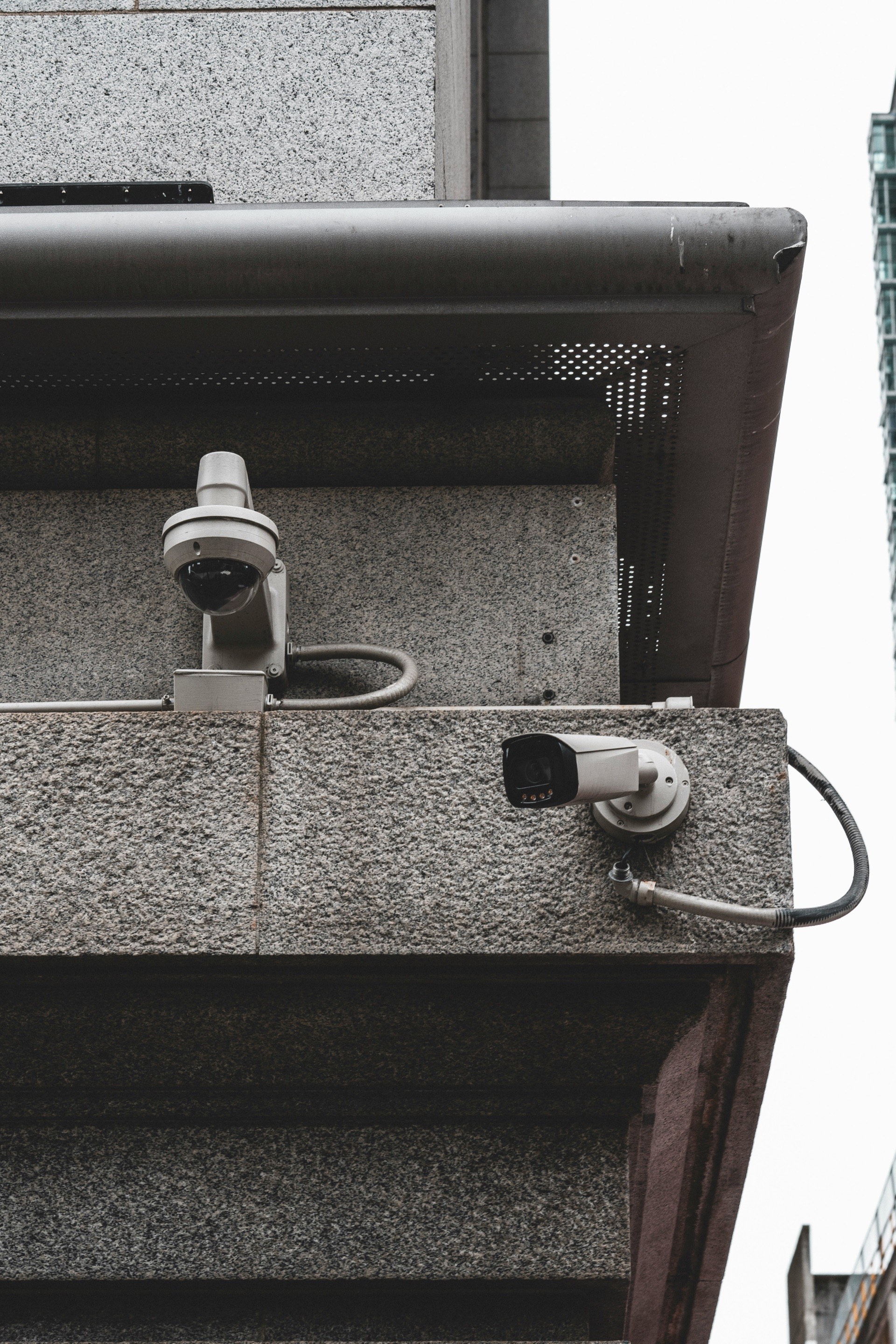 Two CCTV cameras mounted under a building eave